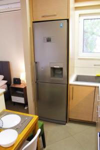 a stainless steel refrigerator in a kitchen with a table at AIOLOS VOULA near the sea apartment in Athens