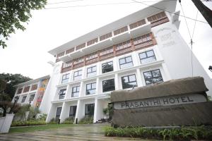 奎隆Prasanthi Hotel的前面有标志的建筑物