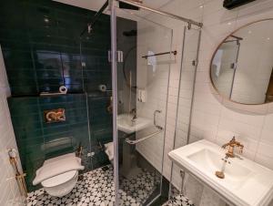 奎隆Prasanthi Hotel的带淋浴、马桶和水槽的浴室