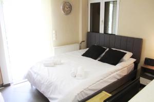 1 dormitorio con 1 cama grande y 2 toallas. en AIOLOS VOULA near the sea apartment en Atenas
