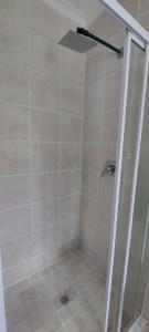 a shower with a glass door in a bathroom at Grey-door cottage Number1 in Glendinningvale