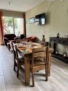 a living room with a wooden table and chairs at Los Tres Pinos in Guatemala