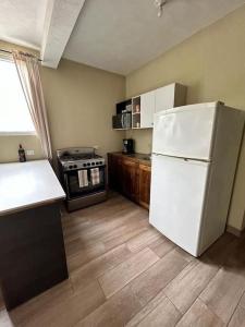 a kitchen with a white refrigerator and a stove at Los Tres Pinos in Guatemala