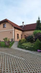 a house with a brick road in front of a building at Penzion U Štoly in Úsilné