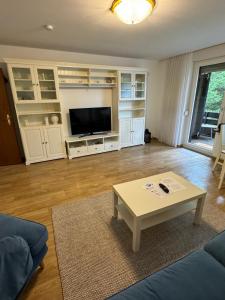 a living room with a couch and a coffee table at Appartement an Möppis Hütte in Winterberg