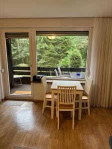 a dining room with a table and chairs and a window at Appartement an Möppis Hütte in Winterberg