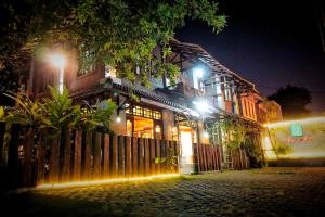 a house with lights on a street at night at Ary's Hotel by Cocotel in Yogyakarta