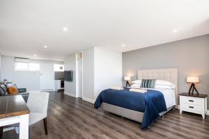 a bedroom with a king sized bed and a living room at The Allegra - 180 degree ocean and city views in Fremantle