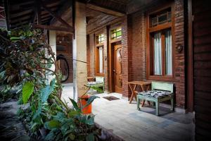 un porche de una casa con un banco y una puerta en Ary's Hotel by Cocotel en Yogyakarta