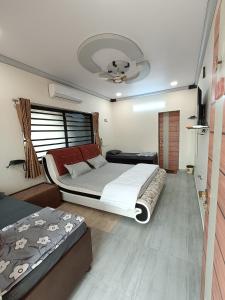 a bedroom with two beds and a ceiling fan at HOTEL JB STAR in Mandvi
