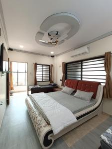 a bedroom with a large bed with a red headboard at HOTEL JB STAR in Mandvi