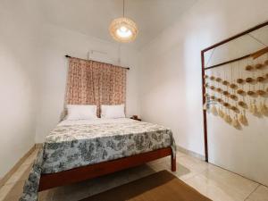 Dormitorio pequeño con cama y ventana en Kamudi Jogja Guesthouse, en Ngabean