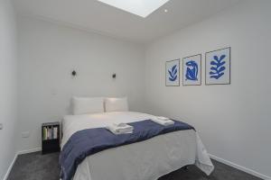 a bedroom with a bed with two towels on it at Inner City Apartments - 2 in Nelson