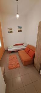sypialnia z łóżkiem z pomarańczową pościelą i poduszkami w obiekcie Downtown Lux Apartments, Subotica w mieście Subotica