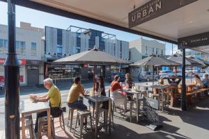 a group of people sitting at tables on a city street at Inner City Apartment 2 - Modern, Rooftop Balcony in Nelson