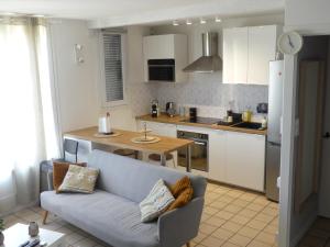 een woonkamer met een bank en een keuken bij superbe duplex avec parking gratuit in Grenoble