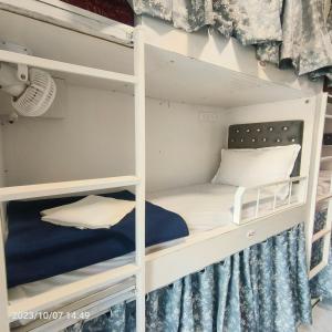 a bunk bed in a room with a white bunk bed at Marol Metro Dormitory in Mumbai