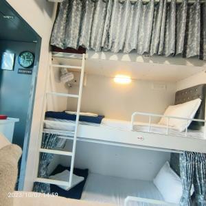 a bunk bed with a ladder in a room at Marol Metro Dormitory in Mumbai