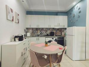 a kitchen with a table and a clock on the wall at The Cozy Nest in Rhodes town in Rhodes Town +5 photos