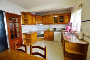 a small kitchen with wooden cabinets and a sink at Azeitao Idílica Moradia T4 no Descanso do Campo in Setúbal