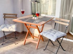 a wooden table with two wine glasses and two chairs at Maryland Apartment in Sofia