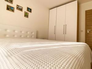 a bedroom with a large bed with white cabinets at Maryland Apartment in Sofia