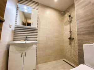 a bathroom with a white sink and a shower at Maryland Apartment in Sofia