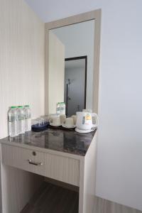 a bathroom counter with bottles of water and a mirror at Fantasy Hill Bungalow in Kata Beach