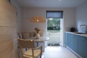 a kitchen with a table with a vase on it at Het Rooversnest in Riel