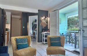 a living room with two chairs and a table at La Kaz à MaLou appartement de standing avec piscine et plage à 800m in Les Trois-Îlets