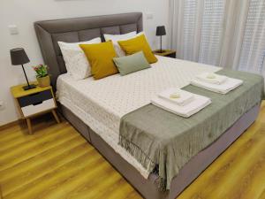1 dormitorio con 1 cama grande con almohadas amarillas y verdes en Apartment in the historic center of Porto, en Oporto