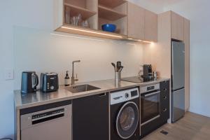 una cucina con lavandino e lavatrice di Inner City Apartments - 3 a Nelson
