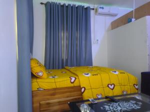 sypialnia z żółtym łóżkiem i żółtym kocem w obiekcie Kingee Lodge w mieście Sunyani