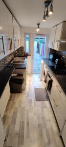 cocina con lavadora en el centro de una cocina en House with great location near Harry Potter studio en Watford