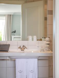 a bathroom with a sink and a mirror at Hotel Watthof in Rantum