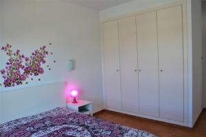 a bedroom with a bed and a pink lamp on a table at Son Xoriguer appartement calme, mer, piscines.Son Xoriguer quiet apartment, sea, swimming pools. in Son Xoriguer +20 photos