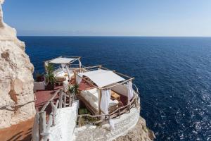 a restaurant on the side of a cliff near the ocean at Son Xoriguer appartement calme, mer, piscines.Son Xoriguer quiet apartment, sea, swimming pools. in Son Xoriguer