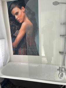 Un cartel de una mujer con un paraguas en un baño. en Villa Lenotre, en Bourges 7 fotos más
