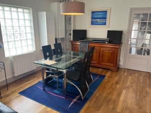 Un comedor con una mesa de cristal y sillas negras. en Villa Lenotre, en Bourges
