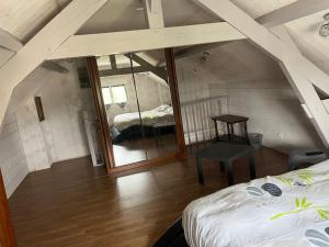 a attic room with a bed and a mirror at Villa Lenotre in Bourges