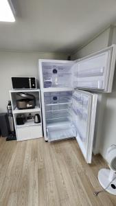 an empty refrigerator with its door open in a room at Jeju stay Jeong in Seogwipo