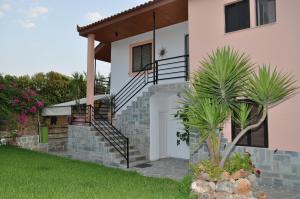 uma casa com uma escada que leva à porta da frente em Olympion Village Studios em Zakharo