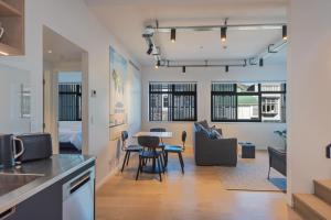 uma cozinha e sala de estar com mesa e cadeiras em Inner City Apartments - 4 em Nelson