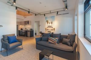 sala de estar con sofá y sillas y cocina en Inner City Apartments - 4 en Nelson