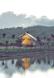 a house with a tent in front of a body of water at Redberry's Luxury Stay in Somvārpet