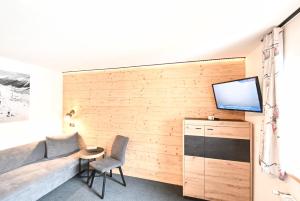 uma sala de estar com um sofá e uma televisão na parede em Vermunt 19a em Galtür