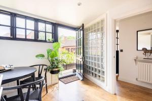 a dining room with a table and a window at 18th Century Converted Coach House 