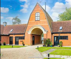 uma igreja de tijolos laranja com uma grande porta em 18th Century Converted Coach House 