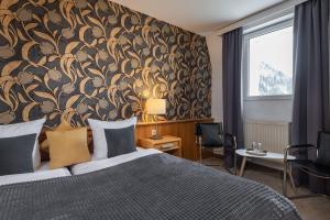 a bedroom with a large bed with a floral wallpaper at Hotel Rader in Bad Gastein