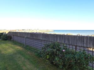 einen Zaun neben dem Strand mit dem Ozean im Hintergrund in der Unterkunft 6 person holiday home in S by in Sæby
